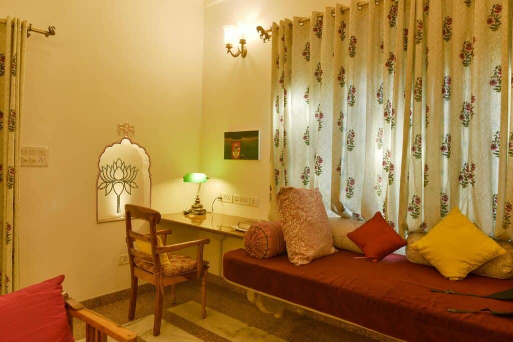 Living the Rajasthani Way Inside Dera Mandawa’s Heritage Suites 2 Window seating with floral curtains inside a heritage suite at Dera Mandawa