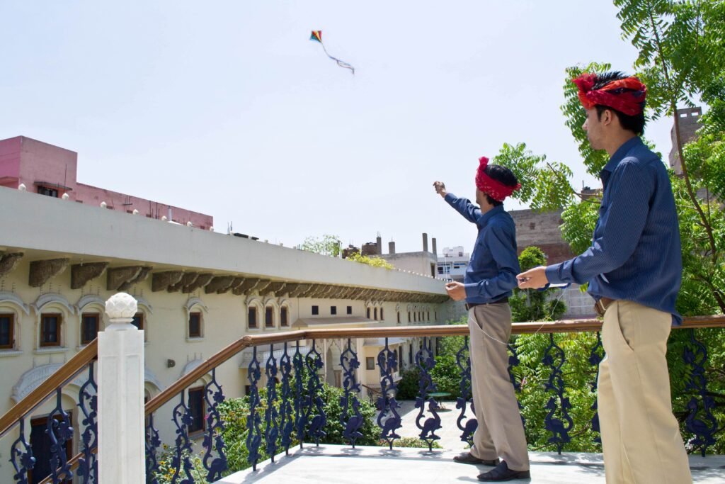 This image depicts a curated "Kite Flying Experience" at the Dera Mandawa heritage hotel in Jaipur, India.