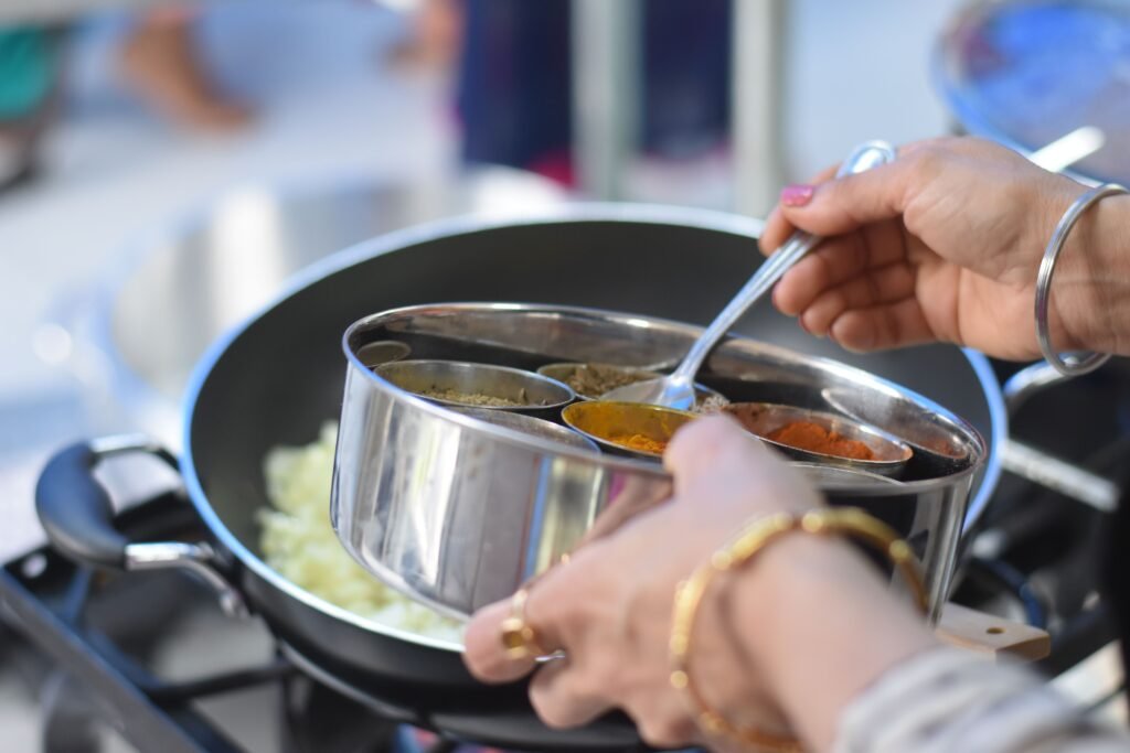 Gourmet Rajasthani Cooking at a Heritage Hotel 1 Hands preparing an Indian dish with spices during Rajasthani cooking classes in Jaipur