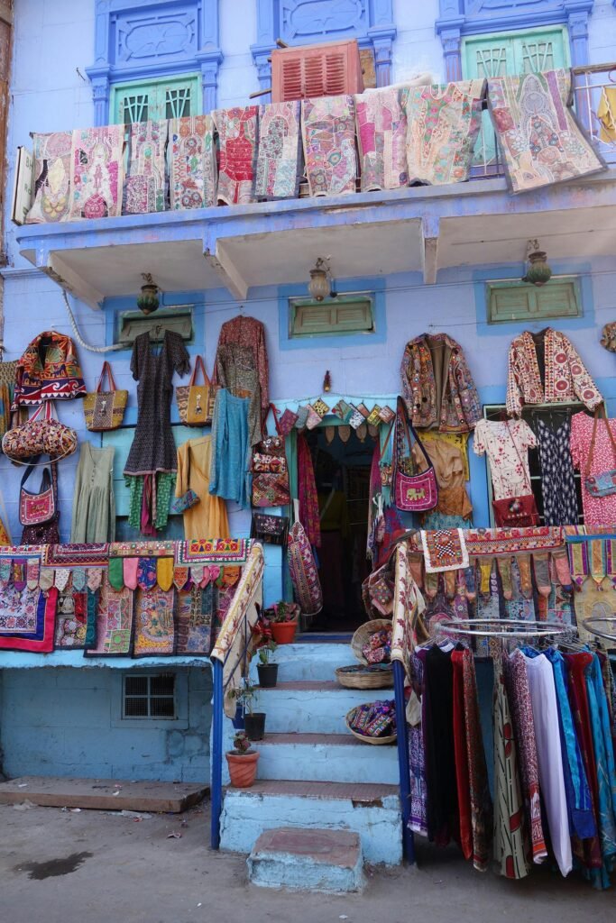 The Guardians of Dwindling Arts: Traditional Craftsmen of Rajasthan 1 Traditional Craftsmen of Rajasthan | A vibrant street market in Jodhpur, India, showcasing handmade textiles and embroidered clothing.