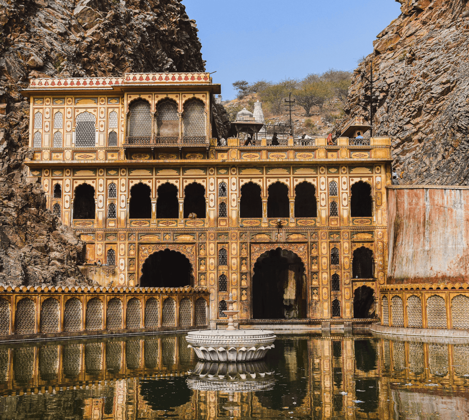 Galtaji Temple in Jaipur, Rajasthan, an 18th-century structure built from pink sandstone and carved directly into the Aravalli hills.