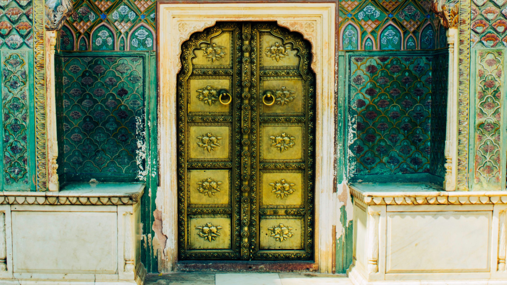 How Jaipur Became the Pink City 2 An ornate teal and gold doorway with floral motifs, part of Jaipur's decorative palace architecture | How Jaipur Became the Pink City