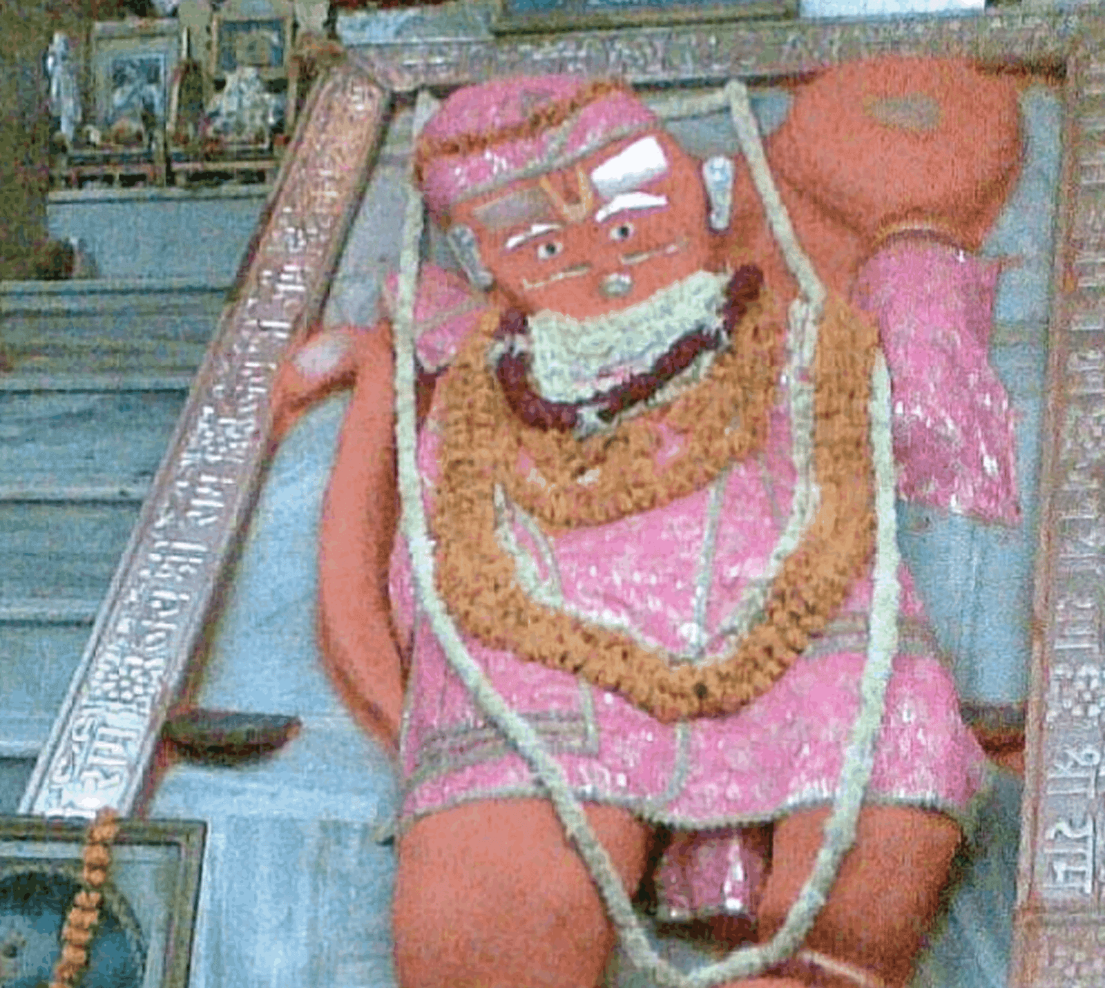 Saffron-coated idol of Lord Hanuman dressed in pink with marigold garlands inside a silver frame at Khole Ke Hanuman Ji Temple in Jaipur