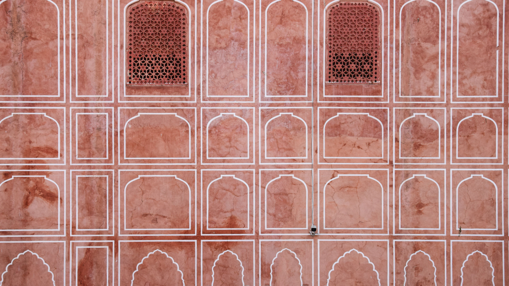 How Jaipur Became the Pink City 1 Pink terracotta wall with white-outlined arches and latticed jharokha windows, showing why Jaipur is called the Pink City