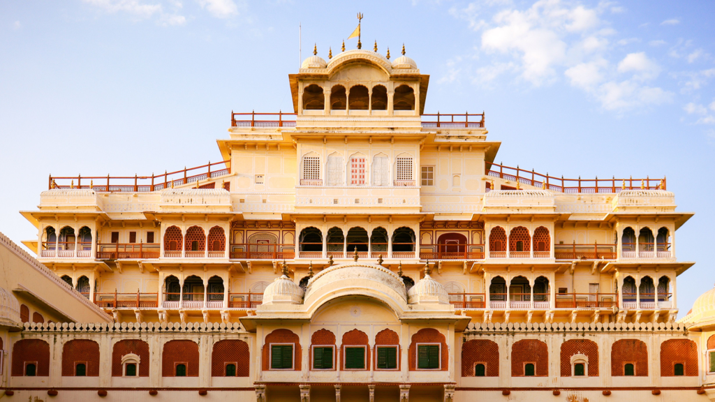 Cream and pink façade of Chandra Mahal at City Palace in Jaipur under a blue sky
