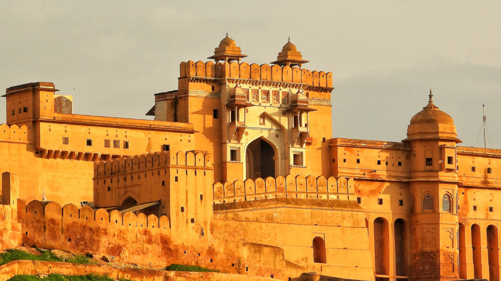 Golden sandstone walls and domed gateway of Amer Fort at sunset, one of the top places to visit in Jaipur with family